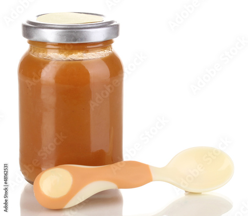 Photo: Useful and tasty baby food with beige small spoon isolated Useful and tasty baby food with beige small spoon isolated