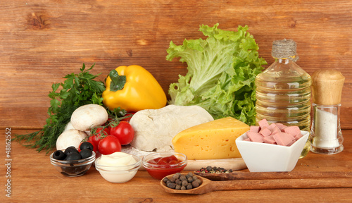 Photo: Ingredients for pizza on brown background Ingredients for pizza on brown background