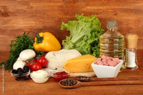 Photo: Ingredients for pizza on brown background Ingredients for pizza on brown background