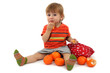 cute little boy eating tangerines, isolated on white