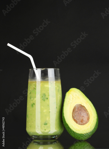 Photo: Useful fresh avocado and half avocado on black background Useful fresh avocado and half avocado on black background