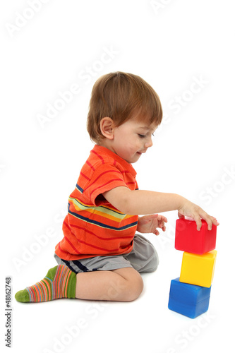 Photo: cute little boy with toy color cubes, isolated on white cute little boy with toy color cubes, isolated on white