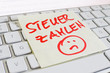 Notiz auf Computer Tastatur: Steuer zahlen