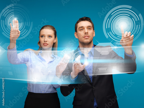 Photo: man and woman working with virtual touch screens man and woman working with virtual touch screens