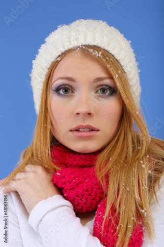 Photo: Young beautiful woman with snow on blue background Young beautiful woman with snow on blue background