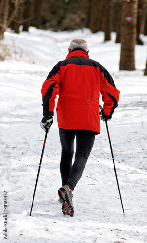 Photo: Senior beim Nordic Walken im Winter Senior beim Nordic Walken im Winter