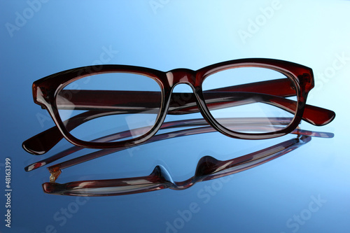 Photo: Beautiful glasses on blue background Beautiful glasses on blue background