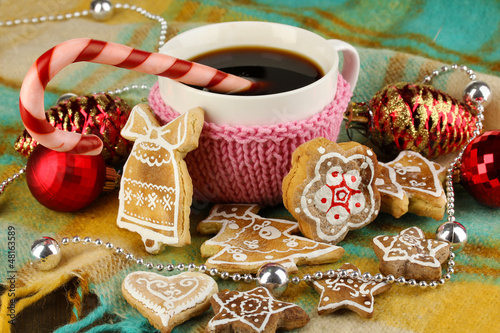 Photo: Cup of coffee with Christmas sweetness on plaid close-up Cup of coffee with Christmas sweetness on plaid close-up