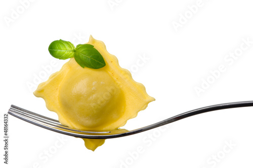 Photo: ravioli pasta parcel and basil garnish on fork white background ravioli pasta parcel and basil garnish on fork white background