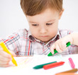 Little boy is drawing on white paper