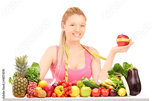 Photo: Female holding an apple wrapped with measuring tape on a table Female holding an apple wrapped with measuring tape on a table