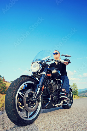 Photo: Biker riding a customized motorcycle Biker riding a customized motorcycle