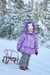 Little girl walking in winter forest