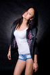 Fashionable Asian girl in a studio in a leather jacket
