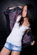 Fashionable Asian girl in a studio in a leather jacket