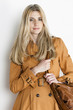 Photo: portrait of standing woman wearing brown coat with a handbag portrait of standing woman wearing brown coat with a handbag