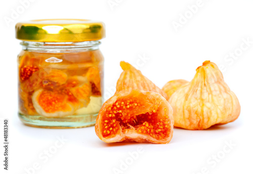 Photo: Delicious figs fruit, and glass jar with figs, on white backgrou Delicious figs fruit, and glass jar with figs, on white backgrou