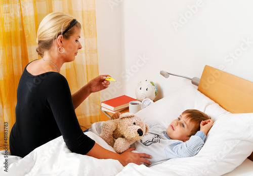 Photo: Mutter und krankes Kind im Bett. Grippe. Mutter und krankes Kind im Bett. Grippe.
