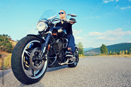 Photo: Young biker posing on a customized motorcycle Young biker posing on a customized motorcycle