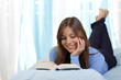 Junge Frau liest im Bett ein Buch