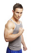 Muscular young man flexing arm muscles in sports outfit