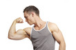 Muscular young man flexing arm muscles in sports outfit