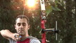 Young man shooting with bow and arrows 