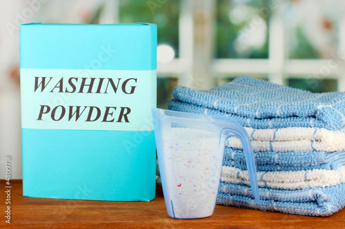 Photo: Box of washing powder with blue measuring cup and towels, Box of washing powder with blue measuring cup and towels,