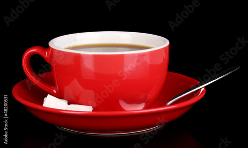 Photo: A red cup of strong coffee isolated on black A red cup of strong coffee isolated on black