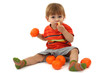 cute little boy eating tangerines, isolated on white