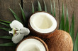 Coconut with leaves and flower, on grey wooden background
