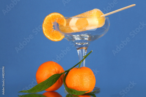 Photo: Yellow fruit juice ice in vase on blue background Yellow fruit juice ice in vase on blue background