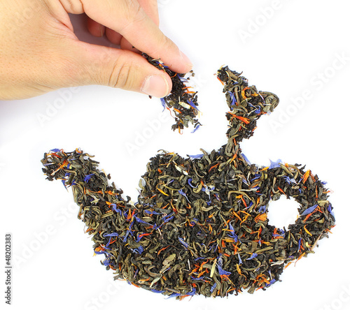 Photo: hand, putting a pinch of tea in teapot hand, putting a pinch of tea in teapot