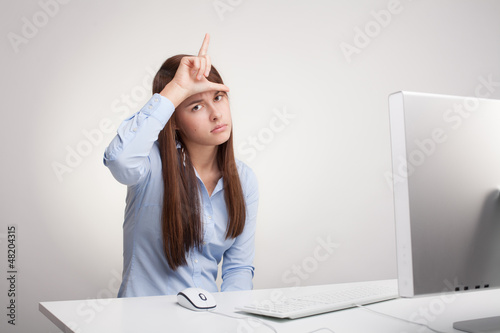 Photo: Ofiice worker is showing loser sign Ofiice worker is showing loser sign
