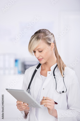 Photo: ärztin schaut auf tablet-pc ärztin schaut auf tablet-pc