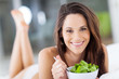 Photo: happy young woman eating green salad on bed happy young woman eating green salad on bed