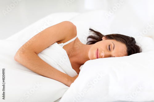 Photo: beautiful young having sweet dreams on bed beautiful young having sweet dreams on bed