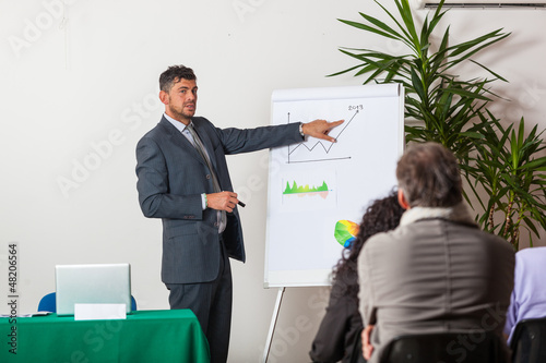 Photo: Young Businessman Explaining Plans and Charts Young Businessman Explaining Plans and Charts