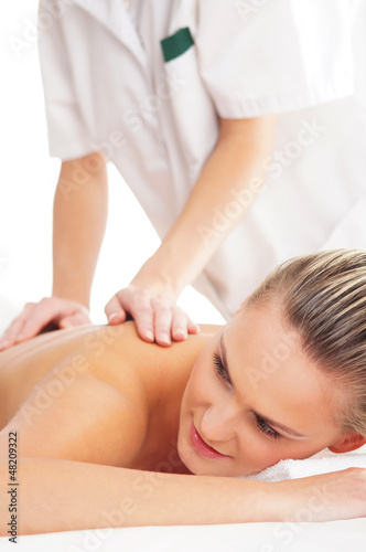 Photo: A young woman laying on a spa massage procedure A young woman laying on a spa massage procedure