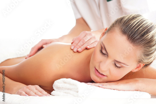 Photo: A young blond woman relaxing on a spa massage procedure A young blond woman relaxing on a spa massage procedure