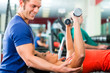 Trainer und Frau im Fitnessstudio, mit Hanteln