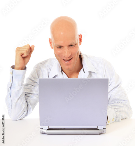 Photo: Attraktiver Mann freut sich während ihr am Laptop sitzt Attraktiver Mann freut sich während ihr am Laptop sitzt