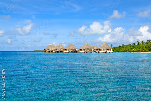 Photo: row of water bungalows on maldives with view over ocean row of water bungalows on maldives with view over ocean