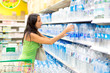 A woman buys a bottle of water in the store