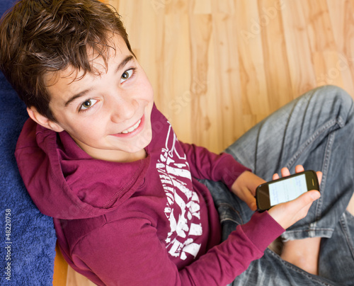 Photo: Freundlicher Junge / Kind mit Smartphone / Handy Freundlicher Junge / Kind mit Smartphone / Handy