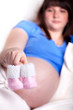 Photo: Babyschuhe mit unscharfer Schwangeren im Hintergrund Babyschuhe mit unscharfer Schwangeren im Hintergrund