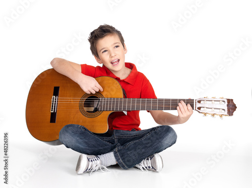 Photo: Smiling boy is playing the acoustic guitar Smiling boy is playing the acoustic guitar