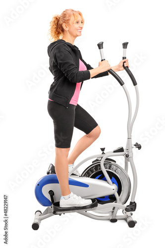 Photo: Mature woman excersing on a cross trainer Mature woman excersing on a cross trainer