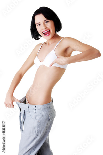 Photo: Young woman showing how much weight did she lost. Young woman showing how much weight did she lost.