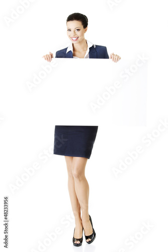 Photo: Smiling business woman showing blank signboard Smiling business woman showing blank signboard